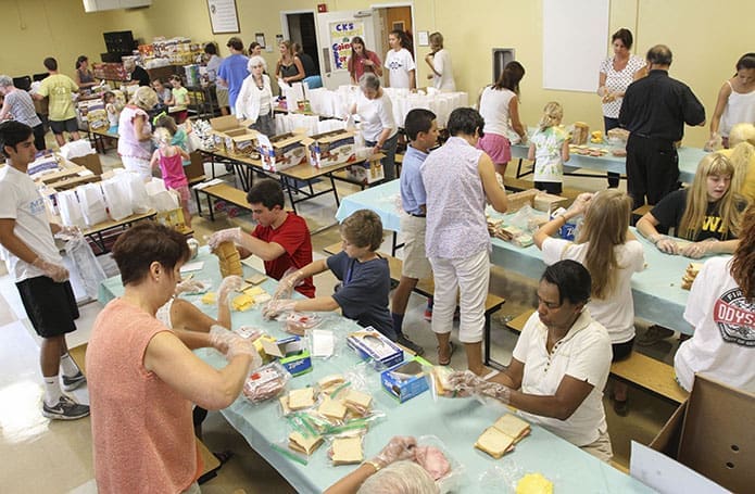 Nearly 60 parishioners from the Cathedral of Christ the King, Atlanta, participated in a sandwich making, bagging and packaging endeavor in the school cafeteria July 13. The sandwiches are given to MUST Ministries for its summer lunch program, where volunteers distribute them during the months schools are on summer break to the children who are eligible to receive a free or reduced lunch during the school year. Photo By Michael Alexander