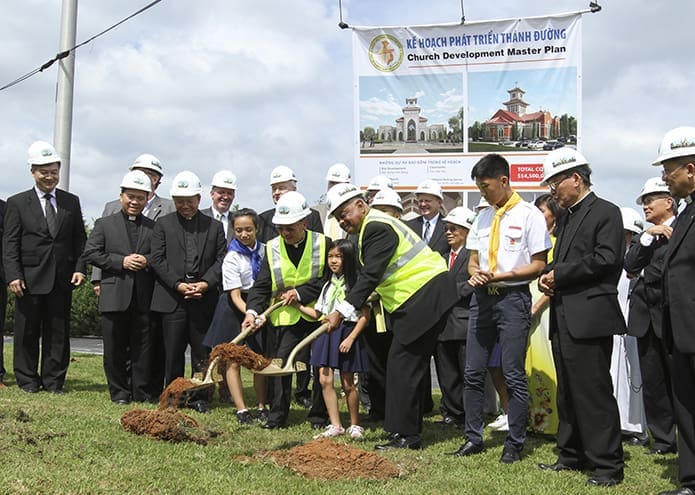 (Foreground center, l-r). Natalie Nguyen, 11, Holy Vietnamese Martyrs Church pastor Father Francis Tuan Tran, Caroline Nguyen, 8, and Archbishop Wilton D. Gregory carry out the ceremonial groundbreaking on the count of one-two-three. Photo By Michael Alexander