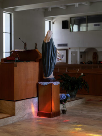 A statue of the Blessed Virgin Mary sits near the altar inside the sanctuary of Corpus Christi Church. Photo by Johnathon Kelso