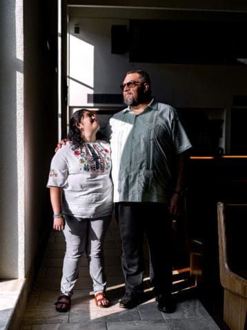 Hector Villanueva with his daughter Bernadette inside the sanctuary at Corpus Christi Church, their place of worship. Photo by Johnathon Kelso