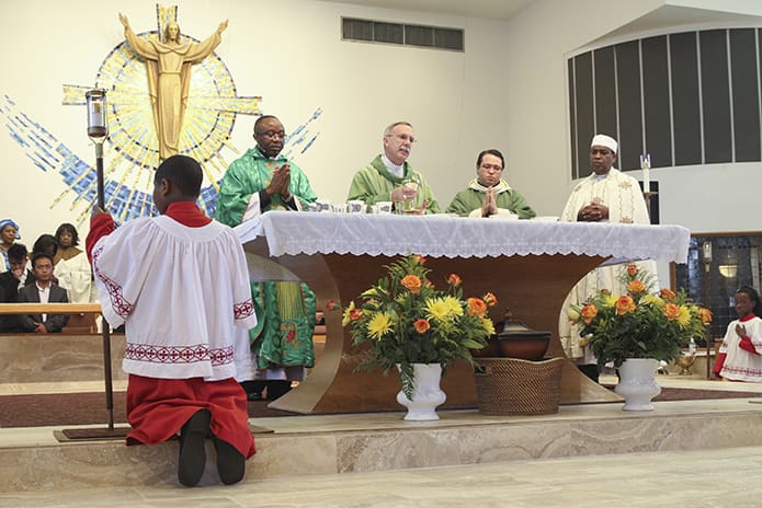Bishop Luis Zarama, holding the chalice, was the main celebrant and homilist for the Oct. 23 rededication Mass at Corpus Christi Church, Stone Mountain. Joining him at the altar are (l-r) Claretian Father Paschal Amagba, pastor of Corpus Christi Church, parochial vicar Father Alex Gaitan and Father Kidanemariam Hadgu Gebrehiwot, vicar for the Catholic Geez Rite Community. Photo By Michael Alexander