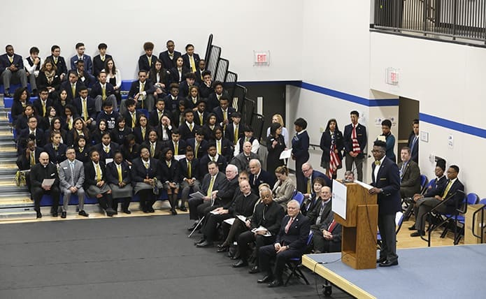 Jahari Fraser, student government president for Cristo Rey Atlanta Jesuit High School’s senior class, standing at the podium, welcomes everyone to the Robert M. Fink Family Gymnasium for the Jan. 30 school building dedication. Photo By Michael Alexander