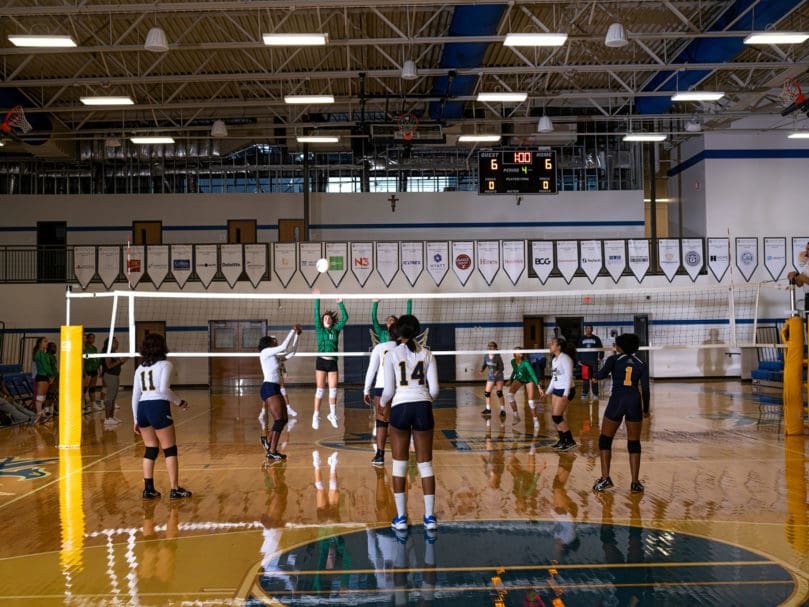 Notre Dame Academy's Eva Sponseller (#11) takes an inside defense position during the fourth set against Cristo Rey. Photo by Johnathon Kelso