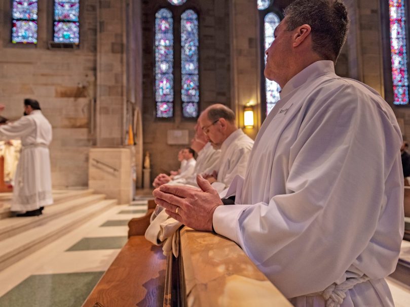 Deacon Rodney Arion prays at the altar rail. Photographer, Johnathon Kelso