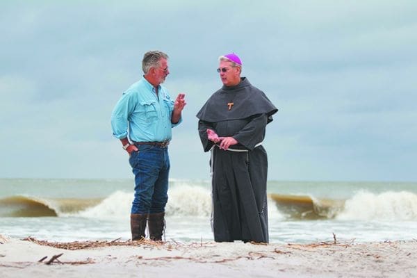 Archaeologist and anthropologist David Hurst Thomas talks with Bishop Gregory J. Hartmayer of Savannah along the shore of St. Catherines Island in Georgia Oct. 14. Earlier in the day, the bishop celebrated Mass on the site of the island's mission church, which dates back to the 1570s and has been the subject of study by Thomas and others for nearly three decades. Scientists on the island continue to excavate with a sense of urgency as erosion from rising sea levels threaten the remains of a vanished American Indian community. CNS photo/Nancy Phelan Wiechec