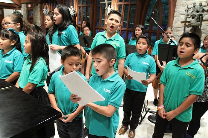 The Divine Child of Jesus youth choir at St. Thomas Aquinas Church, Alpharetta, sings during the weekly Spanish Mass on Thursday evening. The choir has been around for five years and it has 40 members, including vocalists and musicians. Photo By Michael Alexander