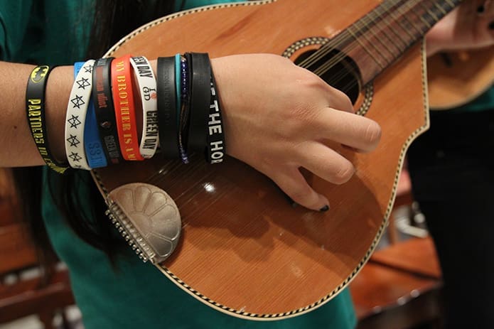 Thirteen-year-old Alondra Quintana plays the mandolin in the choir as she wears the bracelets of all the bands she likes to listen to. Photo By Michael Alexander