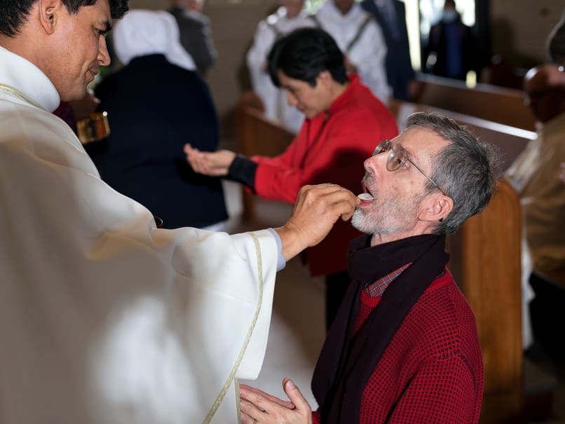 Father Peeter Pedroza administers Communion at Divine Mercy Mission's dedication Mass Dec. 18. Photo by Johnathon Kelso