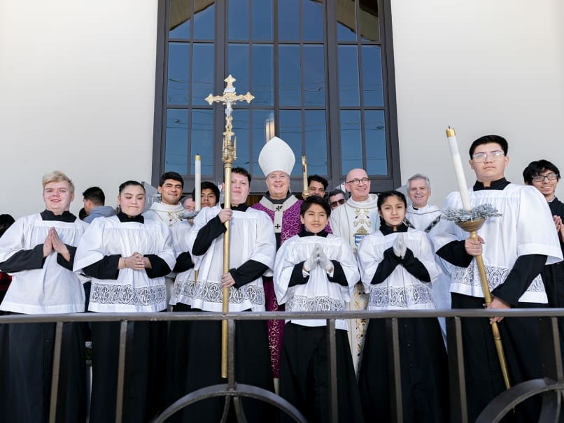 Archbishop Gregory J. Hartmayer, OFM Conv., center, stands with clergy and altar servers following the dedication service at Divine Mercy Mission. He dedicated the mission on Dec. 18. Photo by Johnathon Kelso