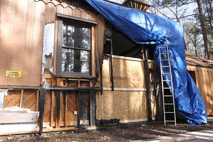 A view behind the tarp reveals the exterior damage to Epiphany Byzantine Catholic Church as a result of a Dec. 14 arson fire. The Roswell church and its 160 member families will worship at nearby Regina Caeli Academy until repairs are completed. Photo By Michael Alexander