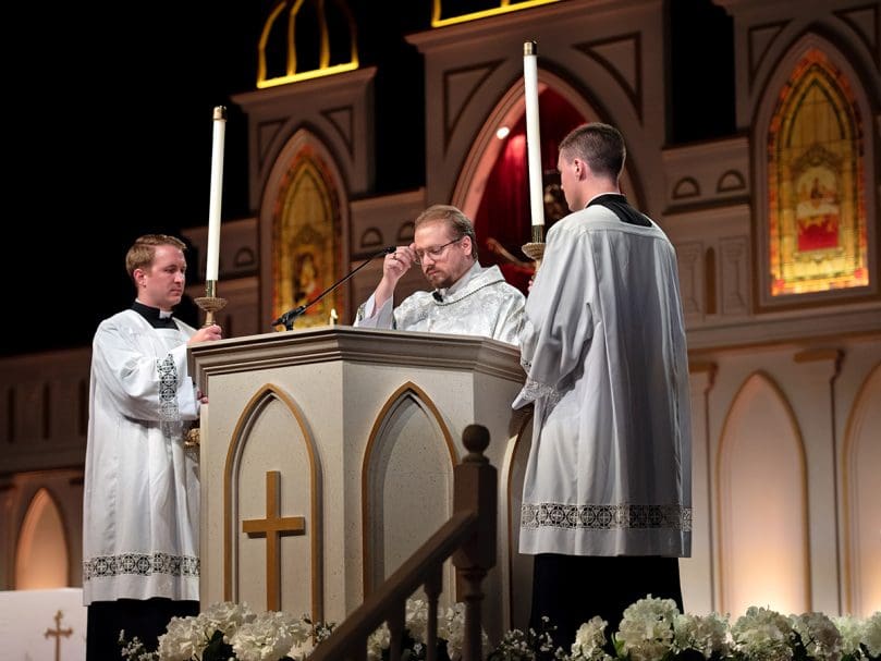 Deacon Matthew Howard crosses his forehead at the reading of the Gospel during the opening Mass on the first day of the 25th Eucharistic Congress at  the Georgia International Convention Center in College Park. Photo by Johnathon Kelso