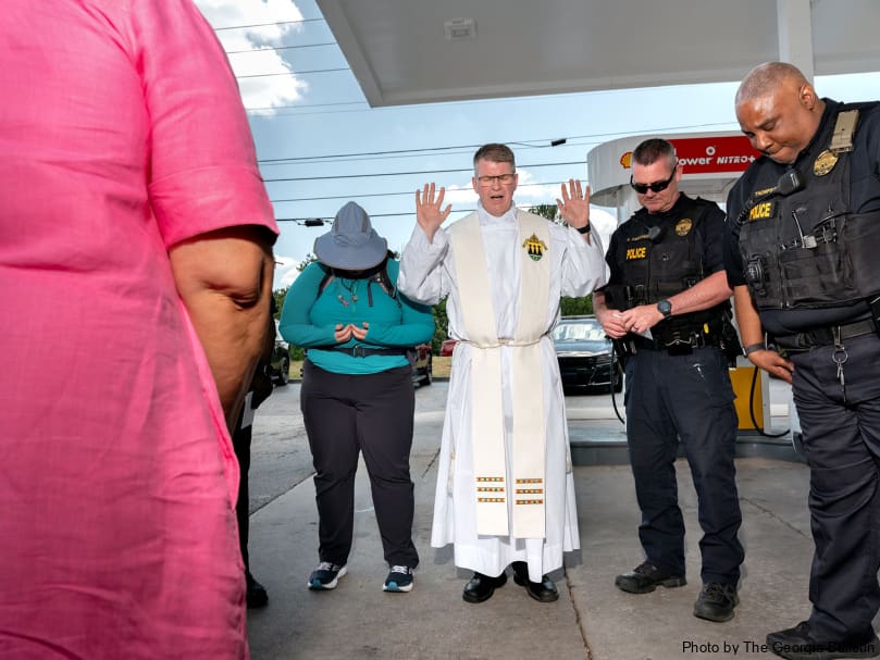 Father Mark McCormick of the Diocese of Rapid City blesses local police and Perpetual Pilgrims during a stop near Riverdale. Photo by Johnathon Kelso