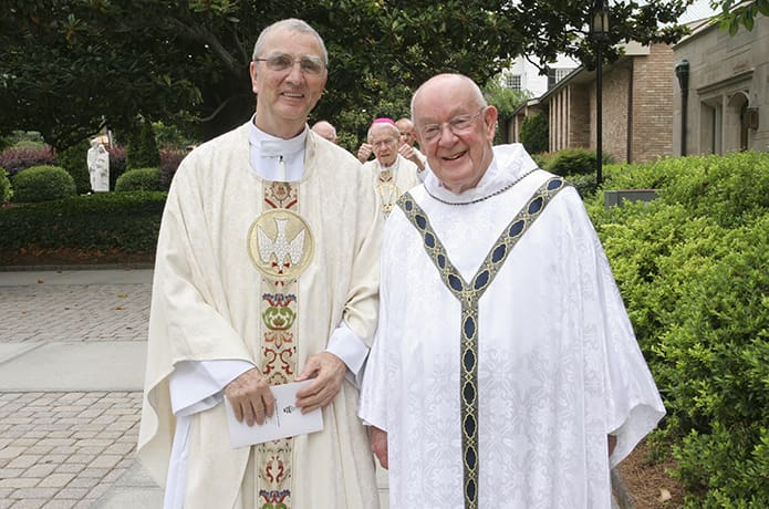 Father Edward O’Connor, left, walks to the entrance of the Cathedral of Christ the King, Atlanta, with senior priest Msgr. R. Donald Kiernan, right, as Archbishop-emeritus John F. Donoghue gives a thumbs-up in the background. This May 26, 2010 photo was taken on the day of the Mass marking the 50th anniversary of Father O’Connor and other jubilarians as priests. Photo By Michael Alexander