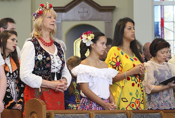 (Front row, l-r) Janine Turchin, representing Poland, Isabella Areiza, representing Colombia, Maried Perez, representing Venezuela, and Cathy Po, representing Philippines, were some of the multicultural members of St. Benedict Church, Johns Creek, who participated in the liturgyâs offertory procession. Photo By Michael Alexander