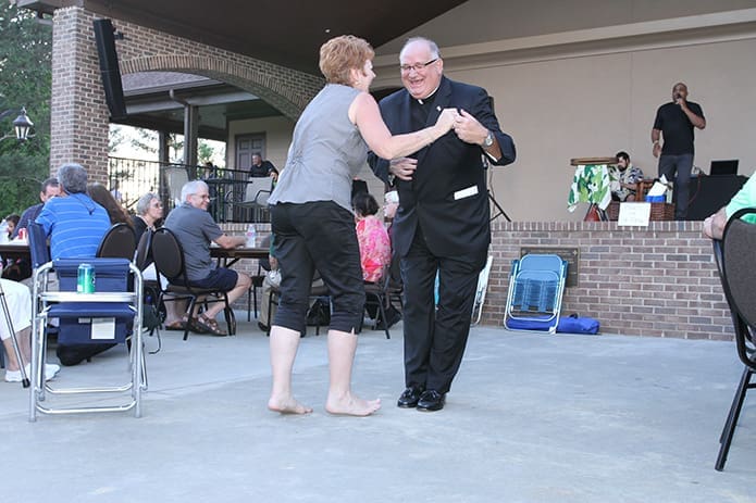 In some circles Father Paul Flood is known for his light on the feet, dancing skills. Here he dances with Jennifer Mercure of St. Mary Church in Toccoa during a celebration that followed Mass at St. Benedictâs Taylor Lodge. Photo By Michael Alexander