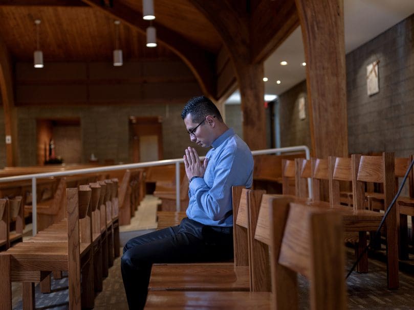 Father Rodrigo Padrón Pérez, MNM, prays in the sanctuary at St. Thomas the Apostle Church. The support of the small community groups at the Smyrna parish helped him decide to pursue the priesthood. Photo by Johnathon Kelso