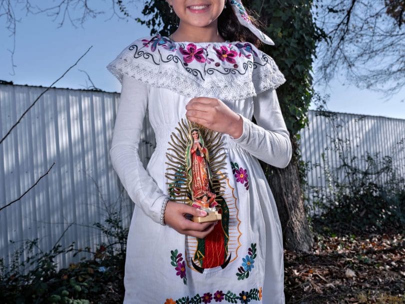 Eleven-year-old Dulche Sanchez hold an icon of our Lady of Guadalupe during a procession to the church at San Felipe de Jesus Church. Photo by Johnathon Kelso