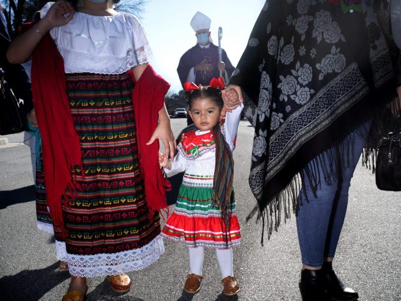 A child walks with her family during a procession for Our Lady of Guadalupe held at San Felipe De Jesús Church Dec. 12. Photo by Johnathon Kelso