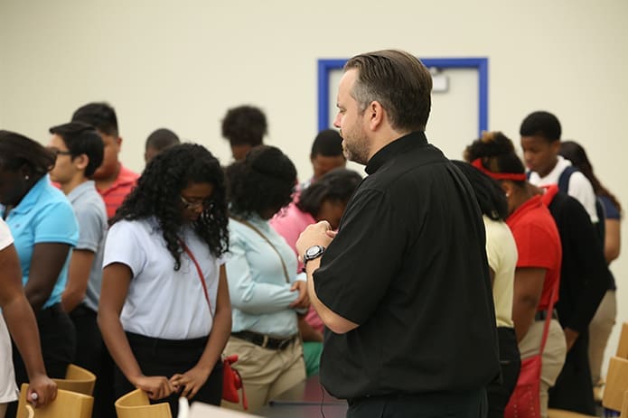 Jesuit Father Todd Kenny, chaplain and teacher, leads the student body in a morning prayer at Cristo Rey Atlanta Jesuit High School, Atlanta. The inaugural freshman class has some 160 students.