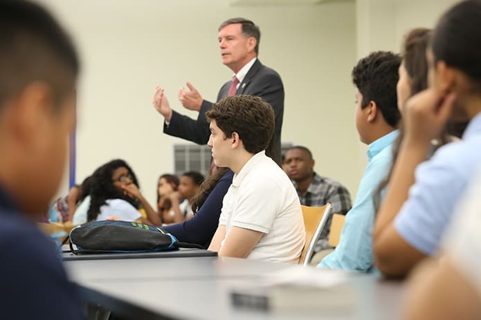 Cristo Rey Atlanta Jesuit High School freshman Abraham Duarte, center, of Forest Park, and his classmates listen to school president Bill Garrett during the morning orientation. In addition to academic studies, pupils will work 45 days a year in a corporate setting. Photo By Michael Alexander