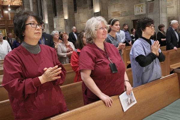 (L-r) Angela Kim of St. Andrew Kim Mission, Duluth, Linda Rozakis of the Cathedral of Christ the King, Atlanta, and Mimi Park of the Korean Martyrs Church, Doraville, have their eyes fixed on the altar during the Communion rite at the Oct. 17 White Mass. All three women are pharmacists at Emory University Hospital, Atlanta. Photo By Michael Alexander