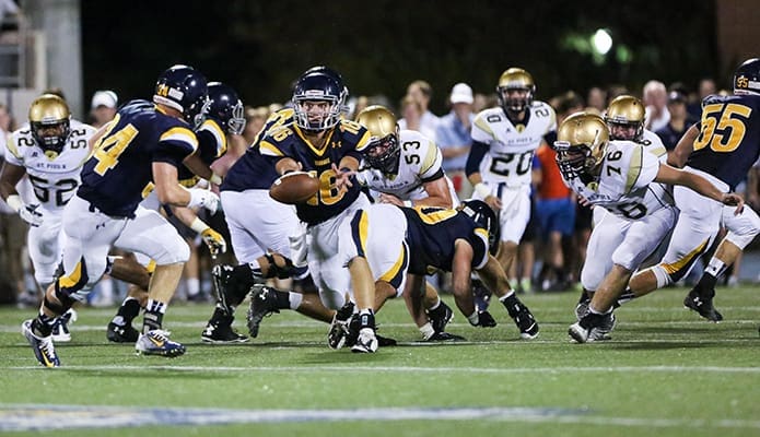 St. Pius defensive end Chris Benjamin (#52) and defensive tackles Andrew Jacon (#53) and Kyle Lewis (#76) look to contain the Marist triple option as Marist quarterback Sam Phelts (#16) pitches the football to running back Griffin King (#34). Photo By Rob Buechner
