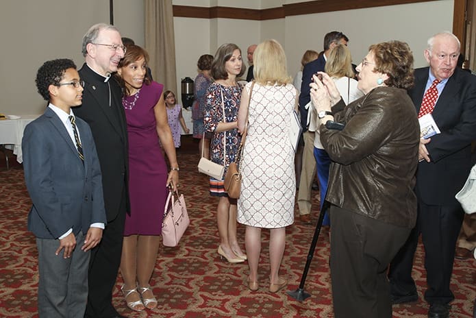 Rosemary Stein of Greenville, S.C., second from right, photographs Christa Singleton and her 12-year-old son, Matthew, with Bishop-designate Joel M. Konzen, SM, during the post-vespers reception. Three of Stein’s sons attended Marist School when Konzen was the principal. Singleton is a 1983 graduate of Marist and Matthew will be attending at the start of the 2018-2019 school year. Photo By Michael Alexander
