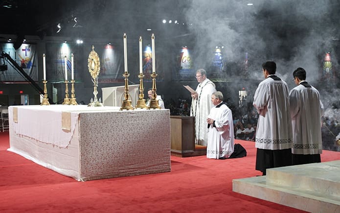 The altar is filled with incense as Father Tim Hepburn, fourth from right, archdiocesan director of vocations, leads the divine praises during Benediction of the Blessed Sacrament. Photo By Michael Alexander