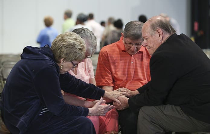 During the healing service, the prayer team of Marie Day, far left and her husband Stephen, far right, pray with Gayle and Ken Low from St. Luke the Evangelist Catholic Church, Raleigh, N.C. The Days attend St. Peter Chanel Church in Roswell. Photo By Michael Alexander