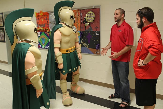 Rob Montepare, second from right, and his colleague Andrew Johnson, far right, take the Titan mascots at Blessed Trinity High School, Roswell, through a training session last fall. Photo By Michael Alexander