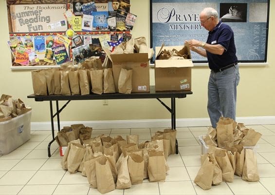 Phil Mooney boxes up the paper bag lunches made by volunteers from Johnson Ferry Baptist Church and Holy Family Church. The two churches participate in a summer lunch project in conjunction with Must Ministries to provide lunches for children in Marietta’s Strafford Ridge apartment complex. Mooney coordinates the volunteers for Holy Family Church. Photo By Michael Alexander