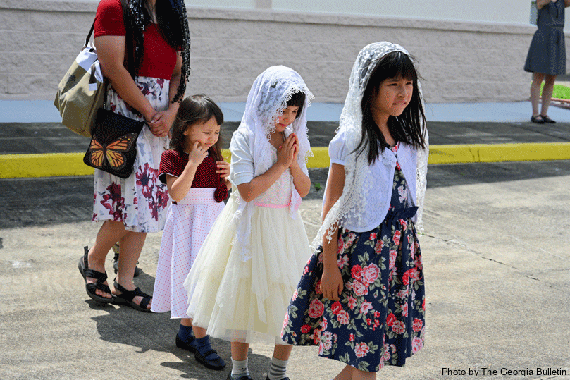 The Grissom sisters walk in a line together while praying during the eucharistic procession around the church grounds of Holy Name  on the Solemnity of Corpus Christi on June 22.  The community held a week-long revival leading up to Corpus Christi. Photo by Julianna Leopold