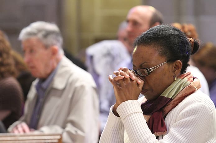 Catherine Joseph, a member of the Cathedral of Christ the King prays in her pew during the Mass for the solemnity of the Immaculate Conception at the Cathedral of Christ the King. The Dec. 8 Mass marked the opening of the Holy Year of Mercy. Photo By Michael Alexander