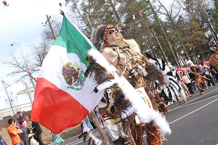 Aldolfo Loma leads the Danza De Apaches dancers in a performance around the rear parking lot of at Our Lady of the Americas Mission, Lilburn, during Our Lady of Guadalupe festivities. Photo By Michael Alexander