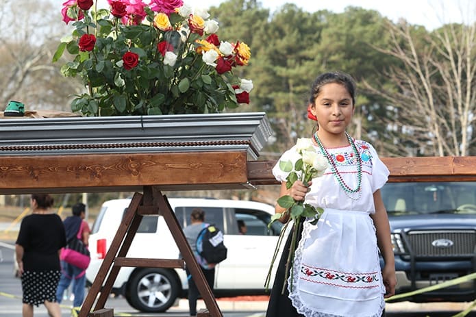 Ten-year-old Carol Duron holds a bunch of flowers she was taking for decoration of  the Holy Door at Our Lady of the Americas Mission in Lilburn. Photo By Michael Alexander