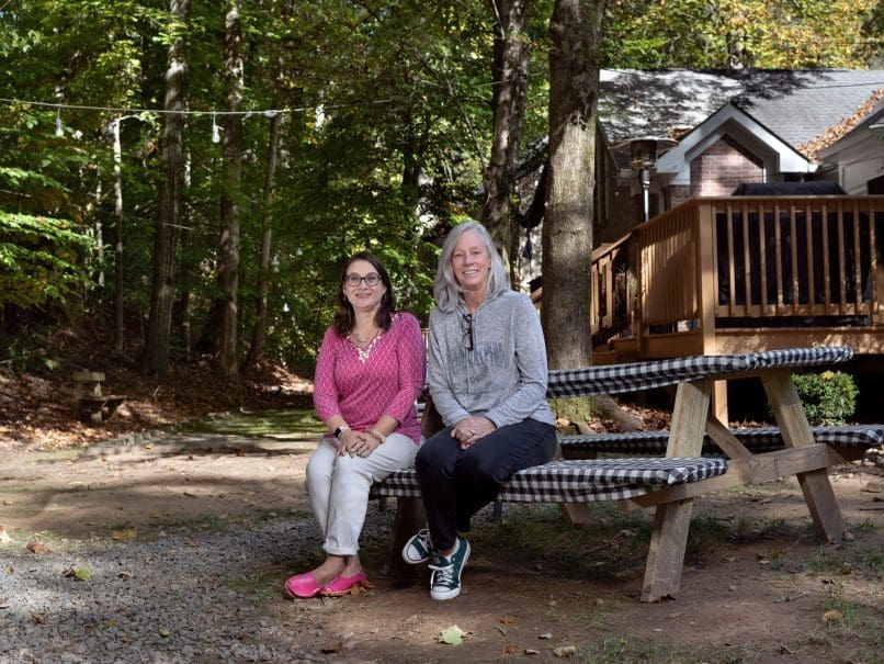 Volunteers Pam Haeger, left, and Leslie McCloskey, right, sit outside the KSU Catholic Center before lunch begins. They and other home chefs prepare delicious meals for the students on a rotating schedule. Photo by Johnathon Kelso