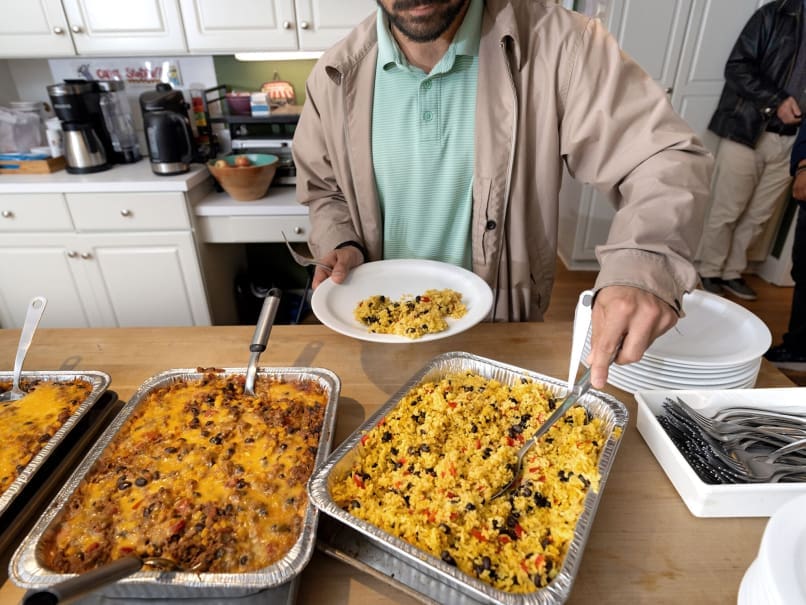 Peyton Smith fills a plate during a free lunch hosted by the Catholic Center at KSU. Volunteers help keep up the beloved meal tradition which dates back more than two decades. Photo by Johnathon Kelso