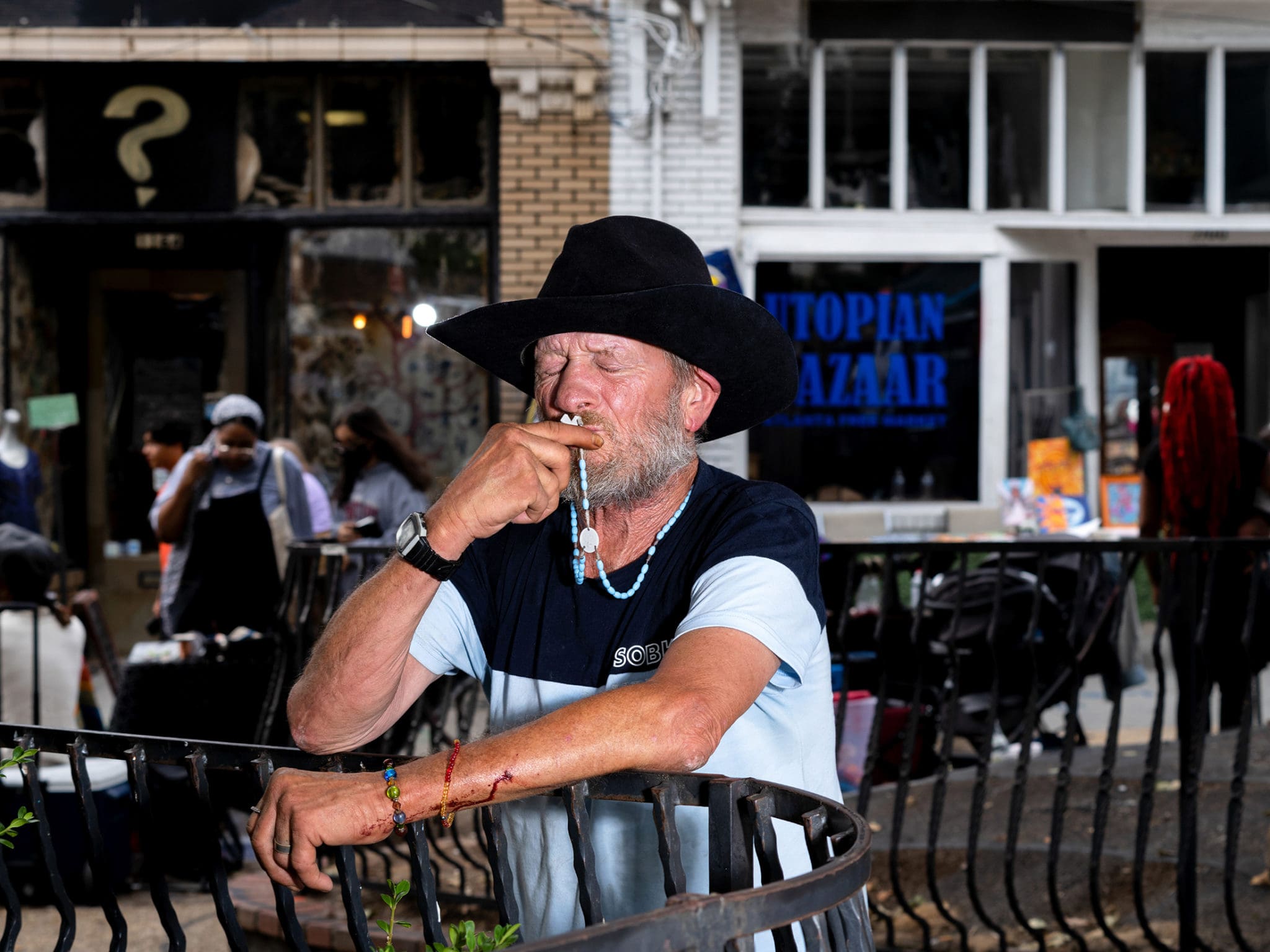 A man kisses a rosary given to him by Legion of Mary members during a day of street evangelization in Little Five Points. Photo by Johnathon Kelso