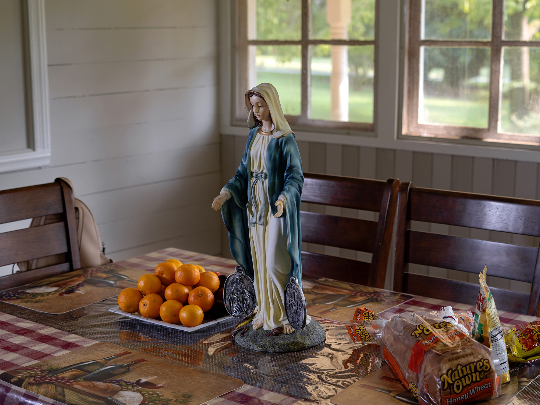 A statue of Our Lady of Grace placed at the dining room table where Brenda and her family live in Tucker. The statue was brought to the home by the Legion of Mary as part of their Pilgrim Virgin Statue Home Visitation Program. Photographer: Johnathon Kelso