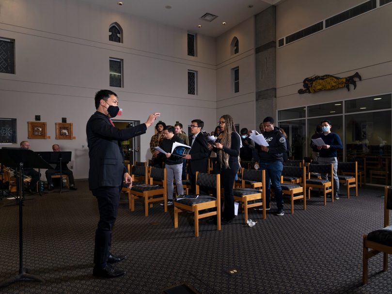 Dr. Joseph Legaspi, director of the Bowman Scholars program leads the audience in a song during the Lessons and Carols event hosted at Lyke House. Photographer, Johnathon Kelso