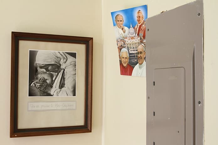 Various images of the soon to be saint, Mother Teresa, can be found hanging around Gift of Grace House like the one by the poster of Pope Benedict XVI, Pope Saint John Paul II, Pope Saint John XXIII and Pope Francis near the driveway entrance to the house. Photo By Michael Alexander