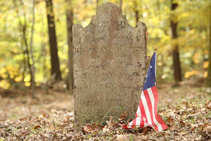 A flag rests beside the tombstone of John Craten at the Locust Grove Cemetery, Georgiaâs oldest Catholic cemetery. The 31-year-old Cratin died in 1826, the same year John Adams and Thomas Jefferson, the second and third presidents of the United States, respectively, also died. For over 30 years an annual All Souls' Mass has been celebrated at the cemetery. Photo By Michael Alexander