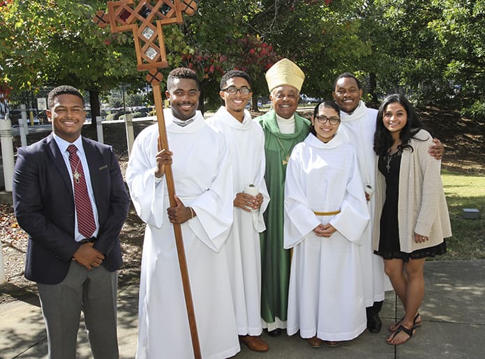 Archbishop Wilton D. Gregory, center, joins students (l-r) Leighton Batiste of Morehouse College, Henry Lubin and Myles Logan of Clark Atlanta University, Sara Moreno Duque of Georgia State University, Gillerm Maguranye of Morehouse College and Robin Jacob of Georgia State University on the plaza of Lyke House following the Oct. 16 anniversary Mass. Photo By Michael Alexander