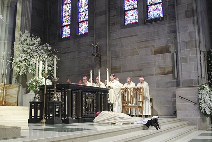 During the Litany of Supplication at his episcopal ordination, Bishop-designate Joel M. Konzen, SM, prostrates himself before the altar at the Cathedral of Christ the King, Atlanta, as all on hand lift their voices in a song of prayer. Photo By Michael Alexander