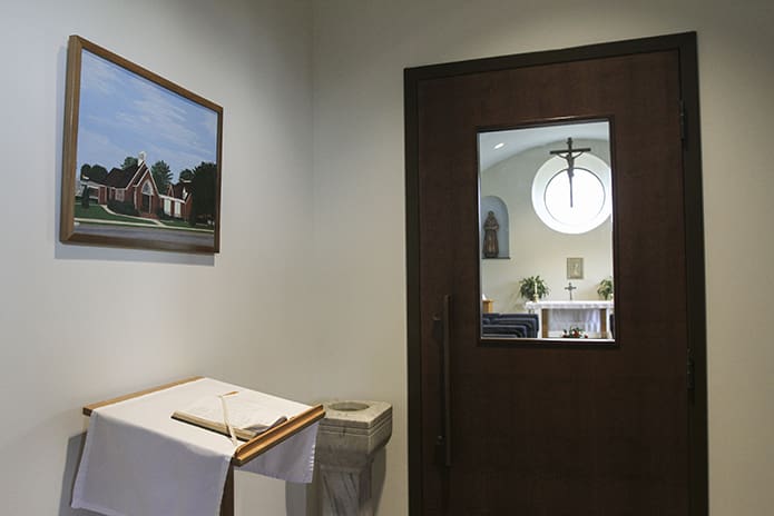 A painting of the old St. Bernadette Church, Cedartown, hangs above the book of remembrance just outside the Our Lady of Lourdes chapel, inside the new St. Bernadette Parish Center. Photo By Michael Alexander
