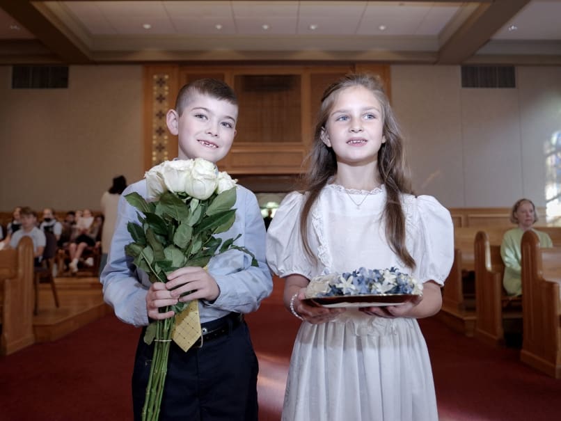 First-grade student Harlan Kelso, left, and second-grade student Charlotte Pettus, right, photographed before processing to the altar during a May Crowning at St. Thomas More Church in Decatur. Both students recently received first Eucharist. Photo by Johnathon Kelso