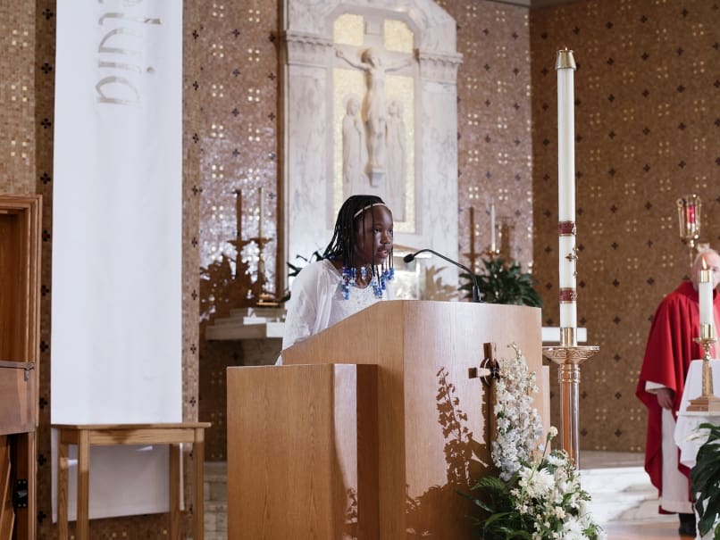 Ryleigh Corthran reads a poem written for her mother during a  Mass held at St. Thomas More Church on May 3. Corthran  is in the fifth grade. Photo by Johnathon Kelso