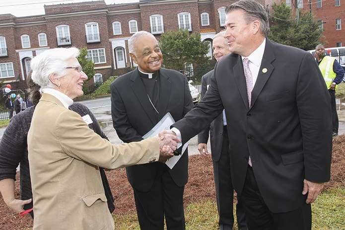 Sister of Mercy Valentina Sheridan, left, greets Eric Clarkson, mayor of Chamblee, as Archbishop Wilton D. Gregory looks on. They were gathering on the site for the Oct. 28 groundbreaking of the new Mercy Care clinic in Chamblee. Photo By Michael Alexander