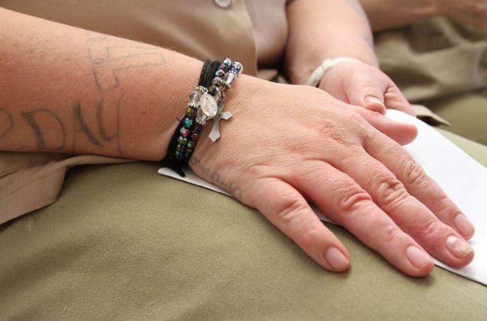 An inmate, who was baptized and confirmed, wears a rosary bracelet, a gift from prison ministry volunteer Dolly Fairclough of St. Thomas Aquinas Church, Alpharetta. Photo By Michael Alexander