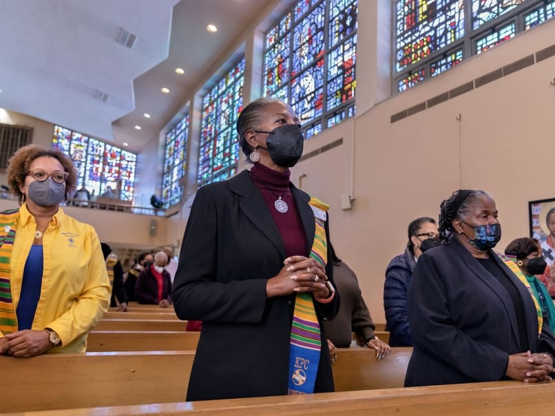 Parishioners and guests stand during the prayers of the faithful during a Mass in honor of Martin Luther King Jr., at Atlanta's St. Paul of the Cross Church. Photo by Johnathon Kelso